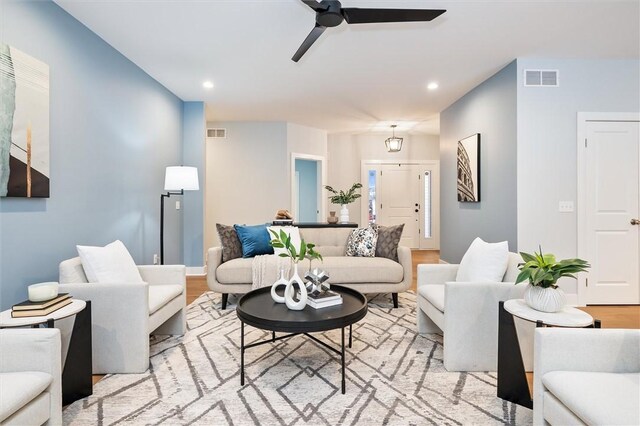 living room with light hardwood / wood-style floors and ceiling fan