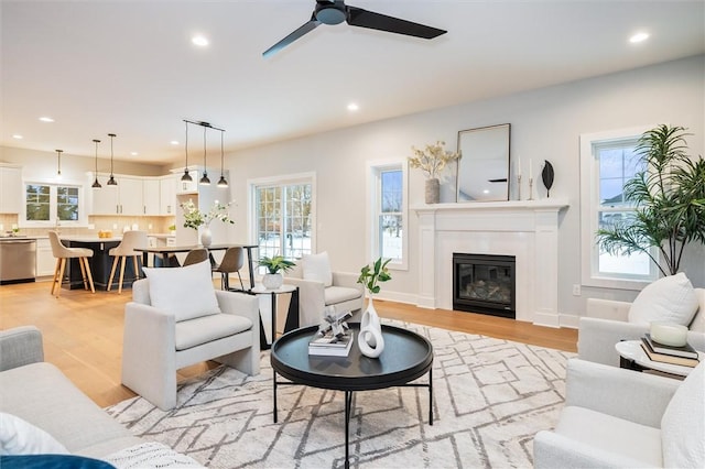 living room with light hardwood / wood-style floors and ceiling fan