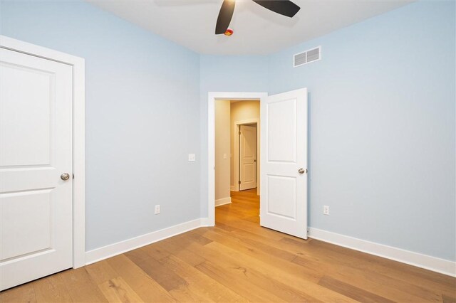 unfurnished bedroom with ceiling fan and light wood-type flooring