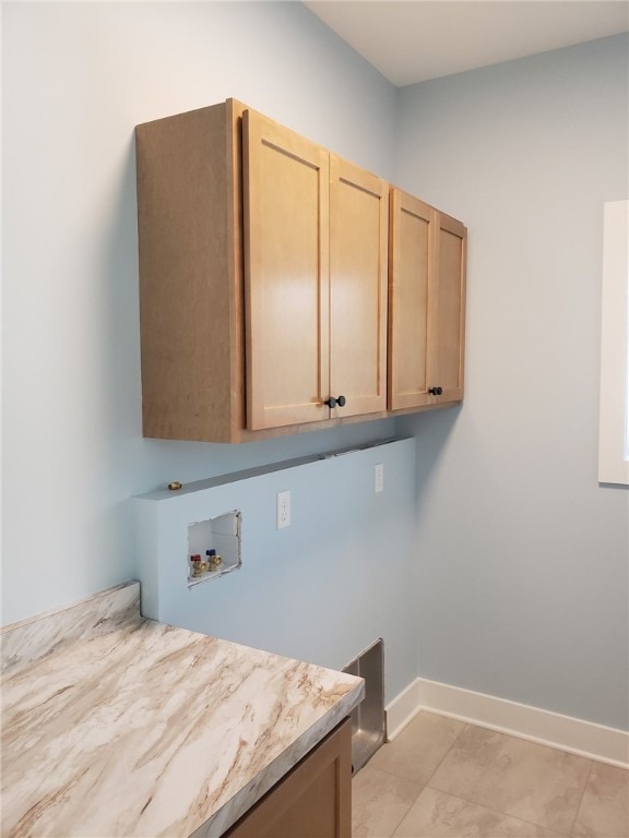 clothes washing area featuring washer hookup, light tile patterned floors, and cabinets