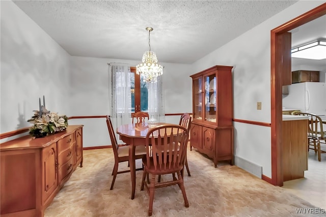 dining room with a notable chandelier and a textured ceiling