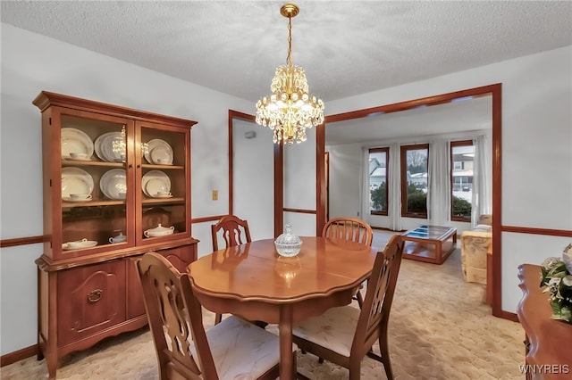 dining space featuring light carpet, a notable chandelier, and a textured ceiling