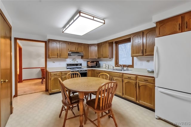 kitchen featuring white fridge, sink, and stove