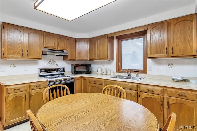 kitchen with range with gas stovetop, sink, and backsplash