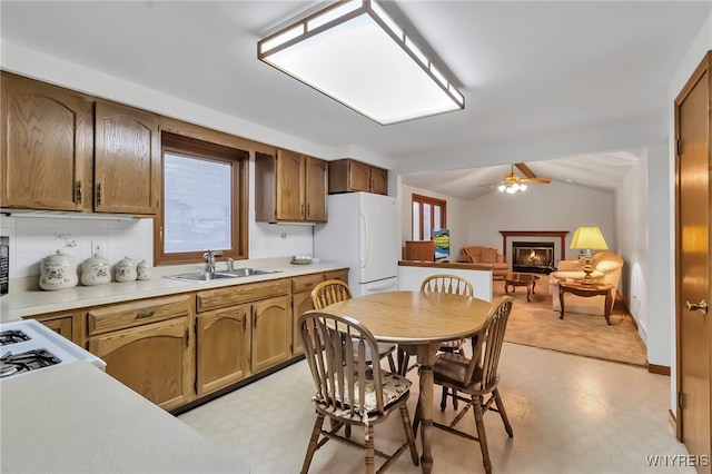 kitchen with lofted ceiling, sink, tasteful backsplash, white fridge, and ceiling fan