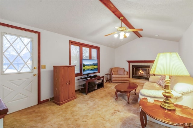 carpeted living room featuring ceiling fan, vaulted ceiling with beams, a textured ceiling, and a fireplace