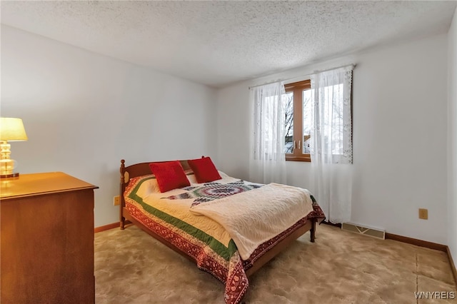 bedroom with carpet floors and a textured ceiling