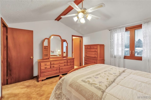 bedroom with ceiling fan, vaulted ceiling with beams, light colored carpet, and a textured ceiling