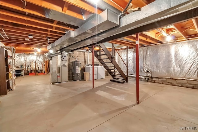 basement featuring washer and dryer, heating unit, and water heater