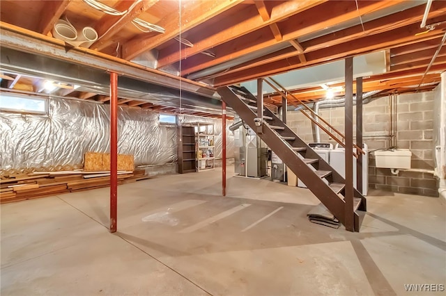 basement with sink, heating unit, and washing machine and clothes dryer