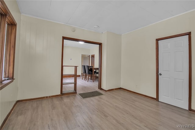 unfurnished room featuring ornamental molding and light wood-type flooring