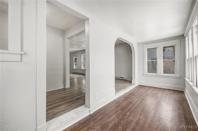 spare room with hardwood / wood-style flooring, a baseboard radiator, and a wealth of natural light