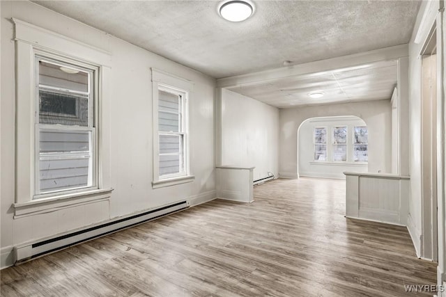 spare room with wood-type flooring, a textured ceiling, and baseboard heating