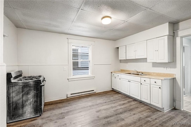 kitchen featuring range with gas cooktop, white cabinetry, sink, a baseboard heating unit, and light hardwood / wood-style floors