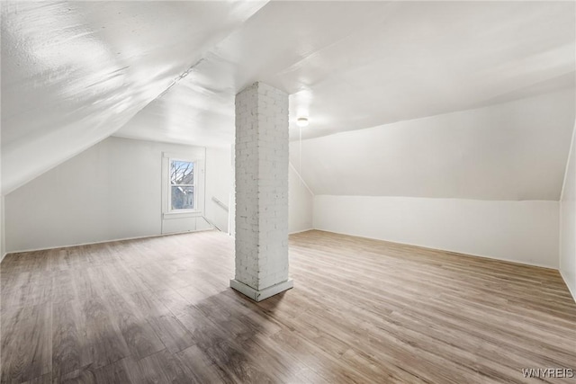 bonus room featuring decorative columns, wood-type flooring, and lofted ceiling