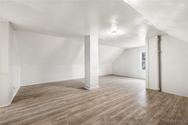 additional living space featuring lofted ceiling and hardwood / wood-style floors