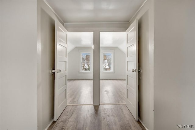 hallway featuring lofted ceiling and light wood-type flooring