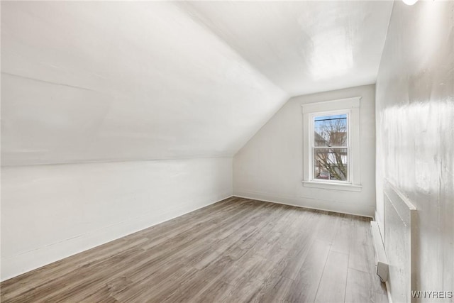 additional living space featuring lofted ceiling and light hardwood / wood-style floors