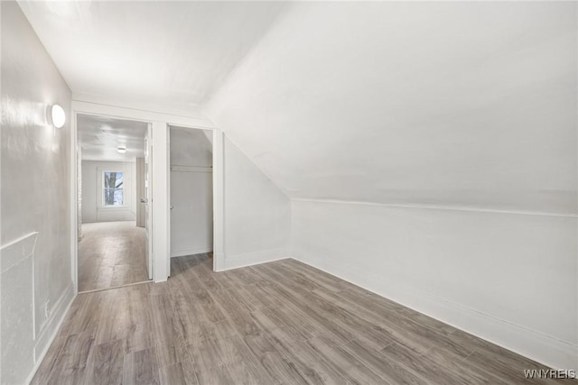 bonus room featuring lofted ceiling and light hardwood / wood-style flooring