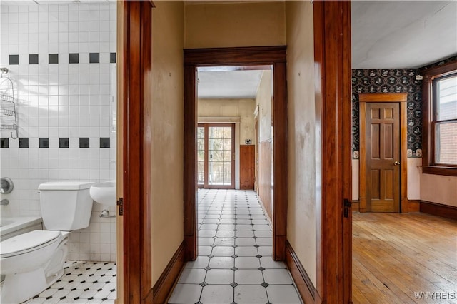 bathroom with tile walls and toilet