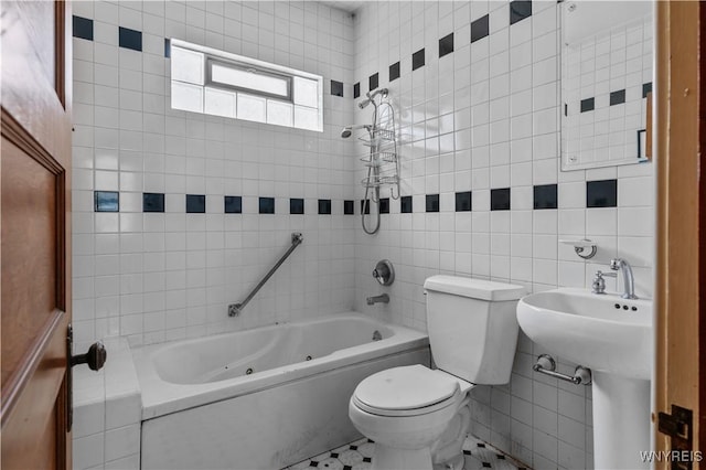 bathroom with tiled shower / bath combo, tile walls, and toilet