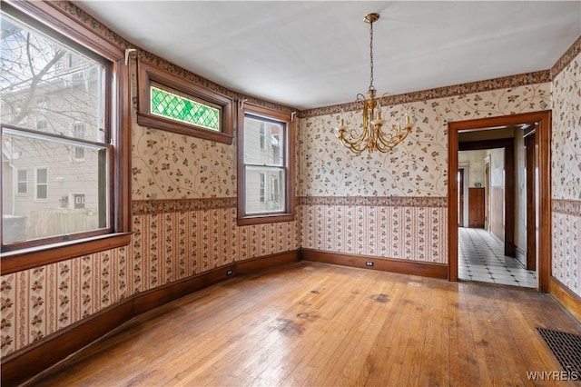 unfurnished room featuring hardwood / wood-style floors and a notable chandelier