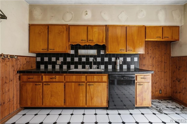 kitchen with sink, decorative backsplash, dishwasher, and wood walls