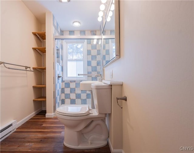 bathroom with sink, hardwood / wood-style flooring, a baseboard radiator, and toilet