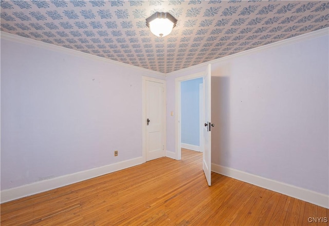 empty room featuring ornamental molding and light hardwood / wood-style floors