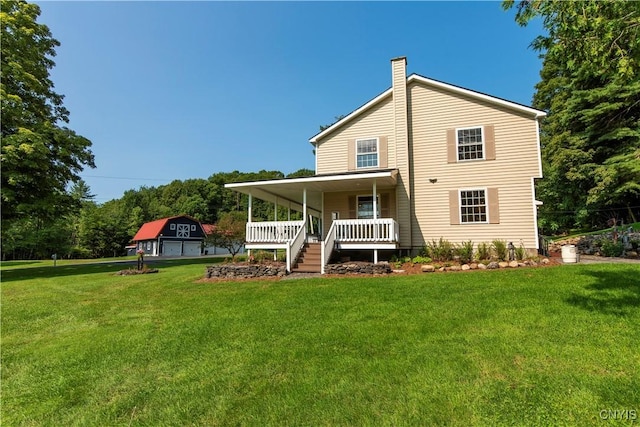 rear view of house with a garage, a lawn, and a porch