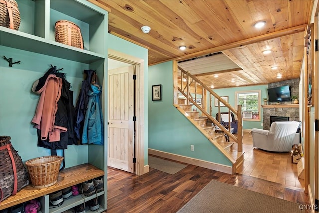 mudroom with dark wood-type flooring, a fireplace, and wood ceiling