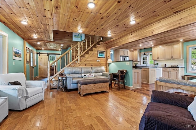 living room with wood ceiling, a barn door, and light wood-type flooring