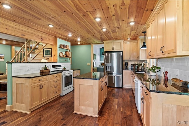 kitchen featuring stainless steel fridge, hanging light fixtures, gas stove, a kitchen island, and light brown cabinetry