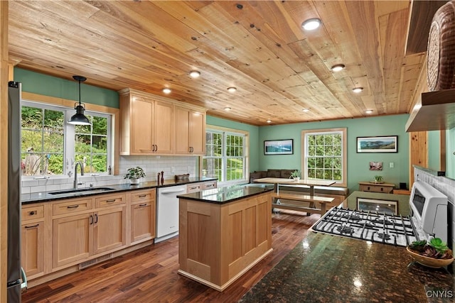 kitchen featuring light brown cabinetry, sink, hanging light fixtures, dishwasher, and backsplash