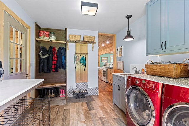 washroom with cabinets, sink, washer and dryer, and light wood-type flooring