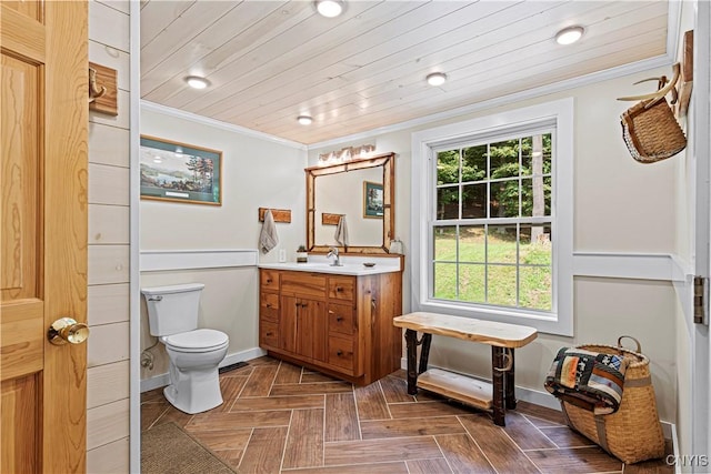 bathroom featuring crown molding, plenty of natural light, parquet floors, and vanity