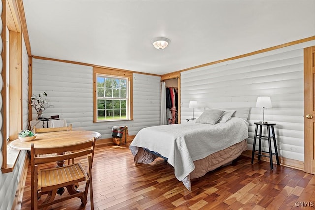 bedroom featuring hardwood / wood-style flooring and log walls