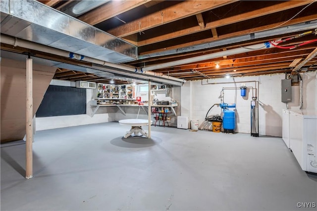 basement with electric panel and washing machine and clothes dryer