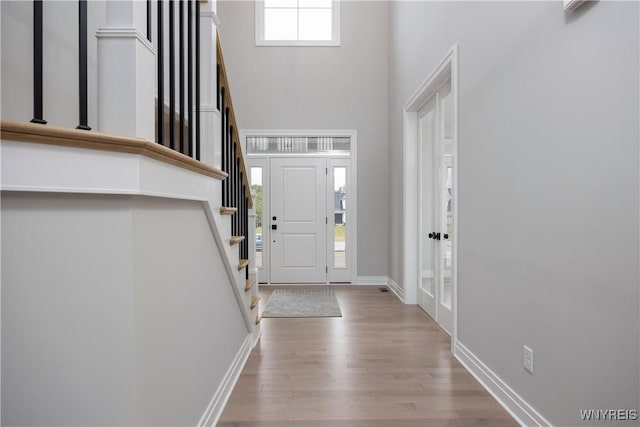 entrance foyer with plenty of natural light, a high ceiling, and light wood-type flooring