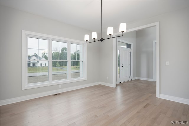 60 Woodthrush Trl, Orchard Park, NY 14127 - unfurnished dining area with an inviting chandelier and light hardwood / wood-style flooring