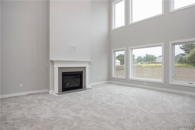 60 Woodthrush Trl, Orchard Park, NY 14127 - unfurnished living room featuring light carpet, a wealth of natural light, and a high ceiling
