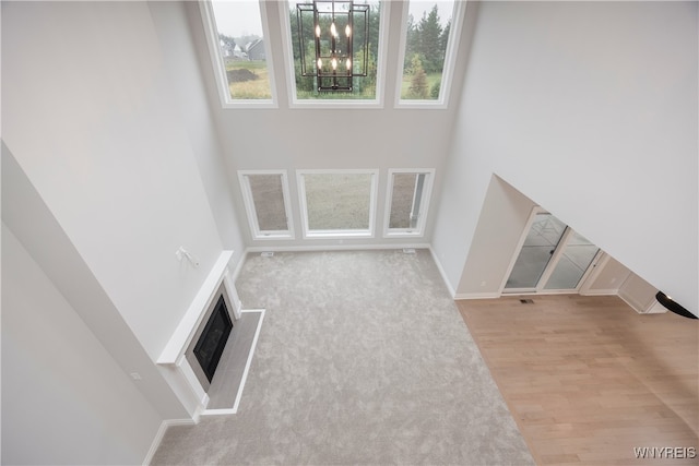 60 Woodthrush Trl, Orchard Park, NY 14127 - unfurnished living room with light hardwood / wood-style flooring and a notable chandelier