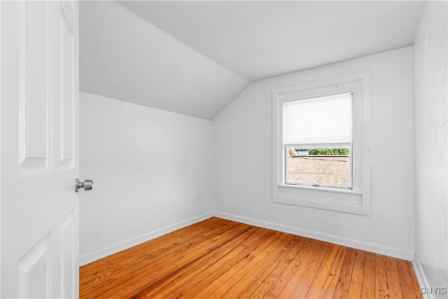 bonus room with hardwood / wood-style flooring and vaulted ceiling