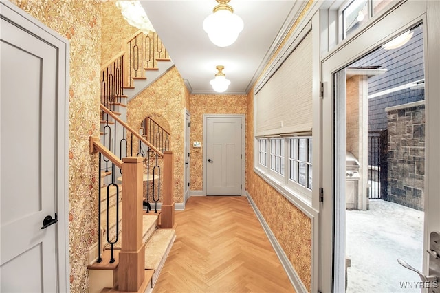 hallway with crown molding and light parquet floors