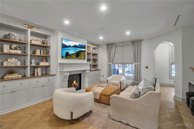 living room with light parquet floors and built in features