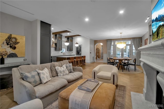 living room featuring light parquet flooring and an inviting chandelier