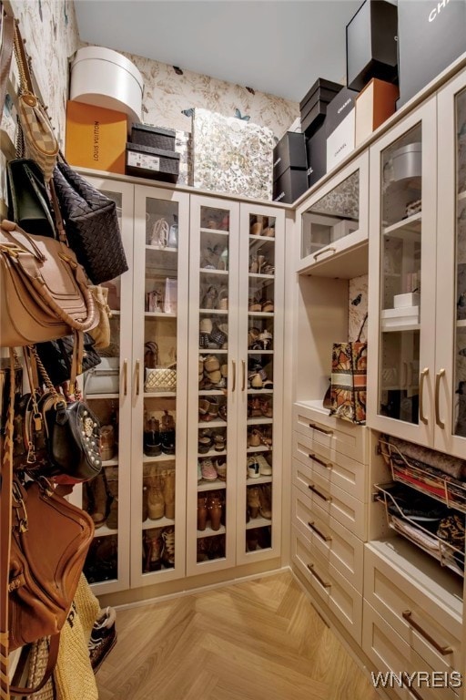 walk in closet with light parquet floors