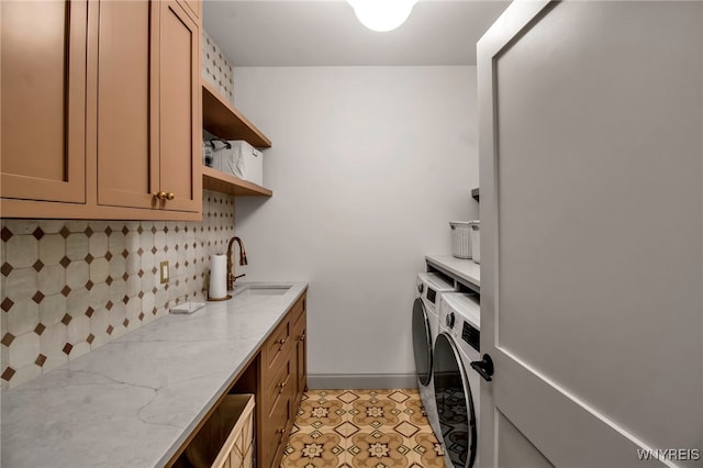 laundry area with sink, cabinets, independent washer and dryer, and light tile patterned flooring