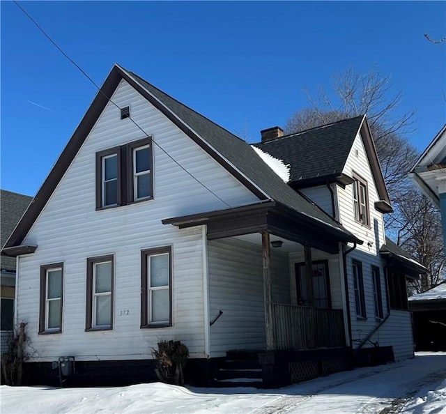 view of snowy exterior featuring covered porch