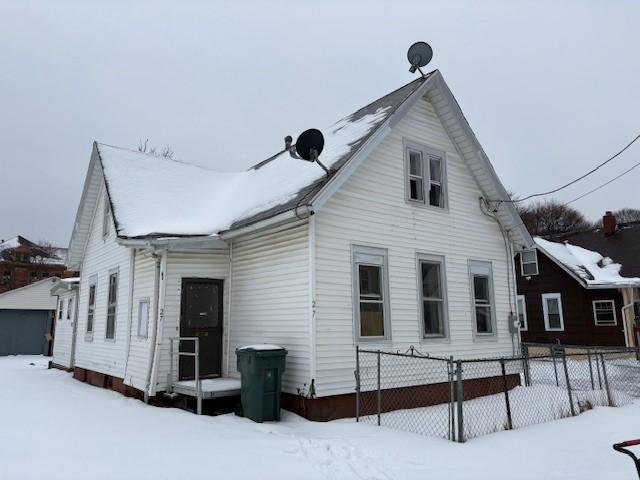 view of snow covered back of property